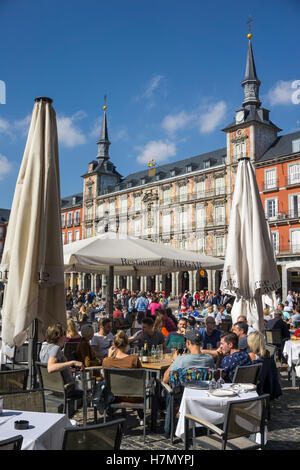 Weekend crowds at cafe tables in the Plaza Mayor in the centre of Madrid, Spain Stock Photo