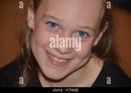Young early teen girl  fresh faced smiling long hair blue eyes Stock Photo