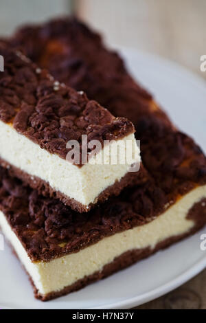 Slice of cheesecake bar with chocolate shortcrust pastry and chocolate crumble Stock Photo