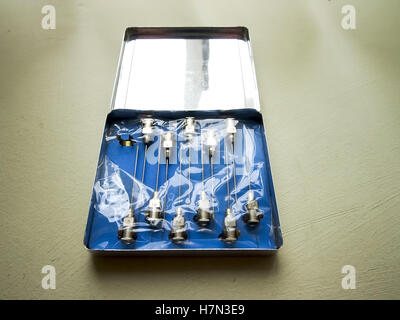 An old tin containing reusable hypodermic needles Stock Photo