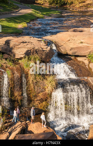 People enjoying the view of Falls Park on the Reedy in downtown Greenville, South Carolina, USA. Stock Photo