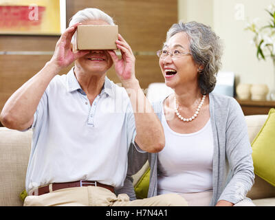 senior asian couple amazed by the technology while trying vr glasses Stock Photo