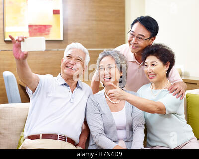 two senior couples taking a selfie on couch at home Stock Photo