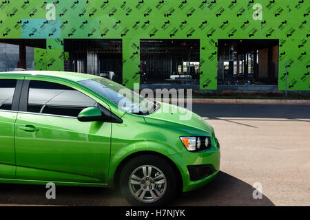 Unusual coincidence of lime green matching colors in an automobile and a building under construction. Oklahoma, USA. Stock Photo
