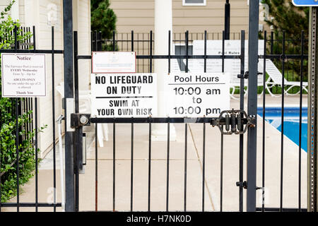 A sign stating no lifeguard on duty, swim at your own risk, for a private swimming pool for a neighborhood association. USA. Stock Photo