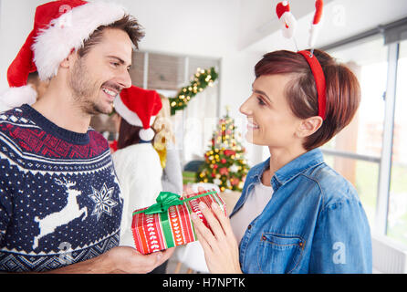 One of couple giving Christmas presents to each other Stock Photo