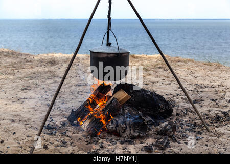 Fish soup. fish soup cooking in a pot on a fire in the forest by the sea Stock Photo