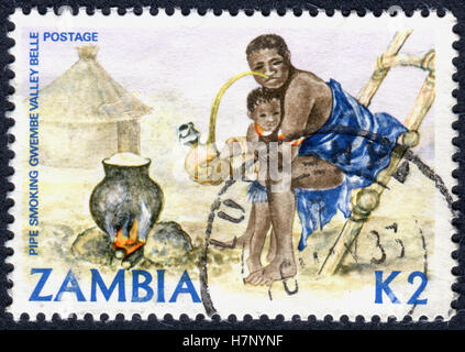 ZAMBIA - CIRCA 1981: A stamp printed in Zambia, is dedicated to Cultural Heritage, shows a Woman smoking pipe, circa 1981 Stock Photo