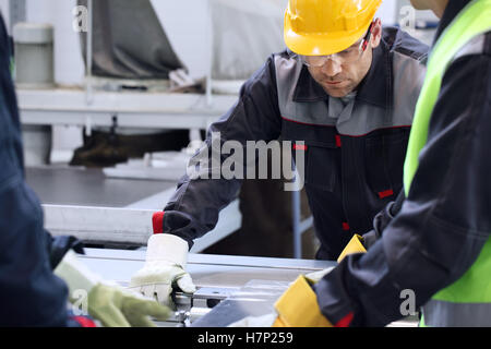 Group of industrial factory workers working with CNC machine Stock Photo