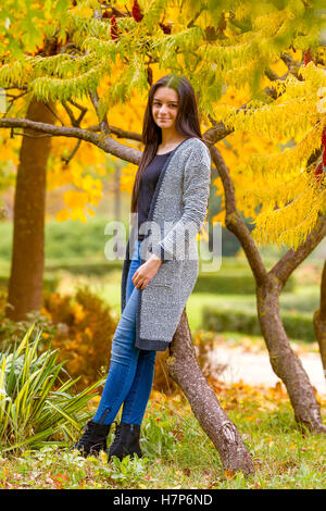portrait of pretty teen girl in autumn park. Smiling happy girl portrait, autumn outdoor. Stock Photo
