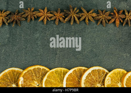 Christmas decoration with anis stars and dried orange slices on old , dark stone kitchen countertop with copy space Stock Photo