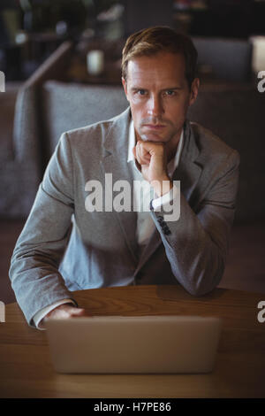 Confident businessman using laptop in cafÃ© Stock Photo