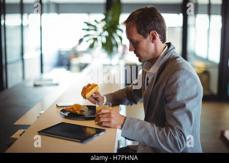 Businessman having breakfast in cafeteria Stock Photo