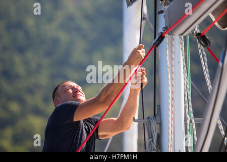 Sailing, man pulling ropes. Luxery yacht boat. Stock Photo