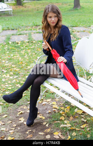 Girl with a red umbrella in the autumn park Stock Photo