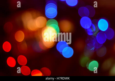 Christmas lights background. Blurred electric garland on Christmas tree. Red, green, yellow, orange, blue glow
