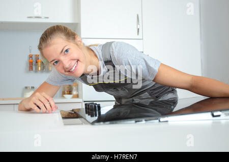 Woman fitting hob into worktop Stock Photo