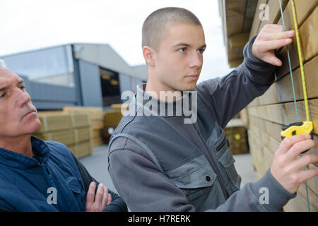 Young man measuring wood Stock Photo