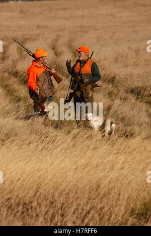 Two Pheasant Hunters With Yellow Lab In Field Stock Photo