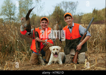 Youth Male Upland Hunters With Pheasant And Yellow Lab Stock Photo