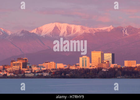 Anchorage Downtown Skyline As Photographed From The Earthquake Park Area Near Sunset, Chugach Mountains And Tall Buildings Show Well In The Pinking... Stock Photo