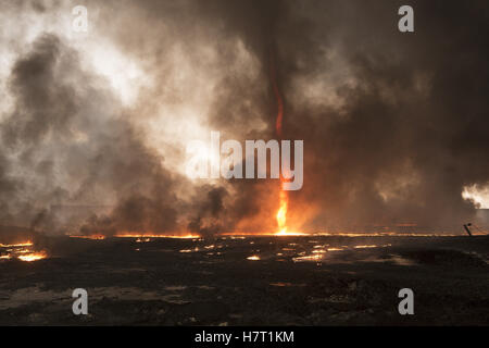 Qayyarah, Niniveh, Iraq. 8th Nov, 2016. 08/11/2016. Qayyarah, Iraq. Smoke and a flaming tornado are seen at a burning oil facility in the town of Qayyarah, Iraq. Oil wells in and around the town of Qayyarah, Iraq, we set alight in July 2016 by Islamic State extremists as the Iraqi military began an offensive to liberated the town.For two months the residents of the town have lived under an almost constant smoke cloud, the only respite coming when the wind changes. Credit:  ZUMA Press, Inc./Alamy Live News Stock Photo