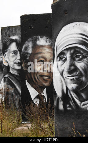 Grass grows near the painted fragments of the former Berlin wall, photographed in Teltow, Germany, 7 November 2016. Some of the fragments are for sale and painted with portraits of famous politicians and activists, such as Nelson Mandela (R-L), Aung San Suu Kyi, Mahatma Gandhi and the Dalai Lama. The wall fell in Berlin on the 9 November 27 years ago.    PHoto: Ralf Hirschberger/dpa Stock Photo