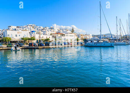 NAOUSSA TOWN, PAROS ISLAND - MAY 17, 2016: white houses of Naoussa port and sailing boats on island of Paros, Greece. Stock Photo