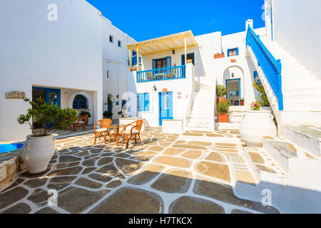 NAOUSSA TOWN, PAROS ISLAND - MAY 19, 2016: table with chairs on courtyard of typical Greek style apartment complex in Naoussa town on Paros island, Greece. Stock Photo