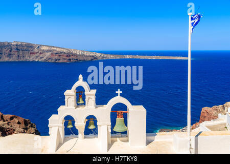 Church tower and Greek flag against blue sea on Santorini island, Greece Stock Photo