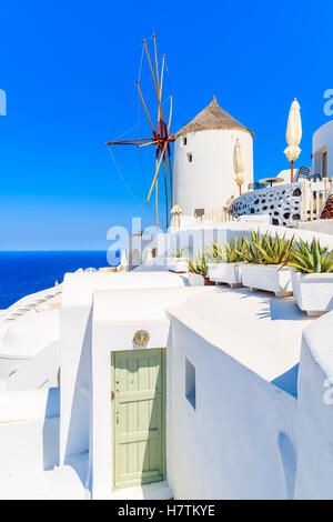 Typical white windmill on street of Oia village, Santorini island, Greece Stock Photo