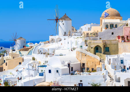 White houses and traditional windmill in Oia village on Santorini island, Greece Stock Photo