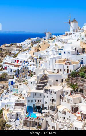 White houses and traditional windmill in Oia village on Santorini island, Greece Stock Photo