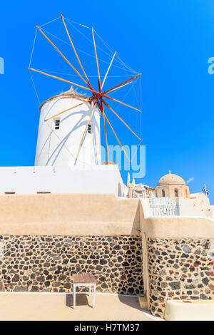 Typical white windmill on street of Oia village, Santorini island, Greece Stock Photo