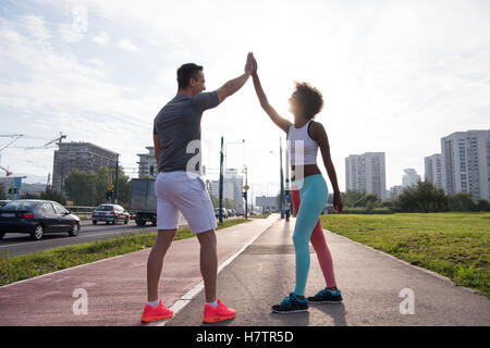 couple congratulating on morning run ginis young sporty mixed rase couple congratulating with hand five after successful morning Stock Photo