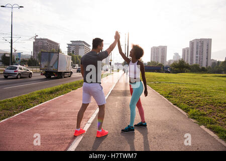 couple congratulating on morning run ginis young sporty mixed rase couple congratulating with hand five after successful morning Stock Photo