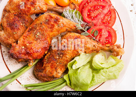 Roasted turkey legs with tomatoes and green salad Stock Photo