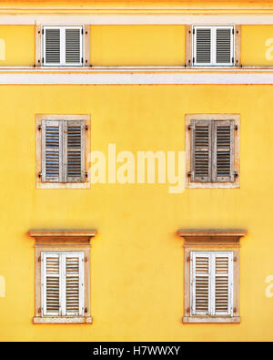 Building facade and old windows with classic wooden venetian shutters blinds, mediterranean europe architecture vintage style Stock Photo