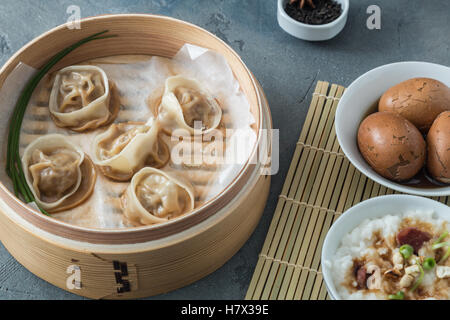 High angled view of cooked dumplings inside bamboo steamer with lip partially off. Stock Photo