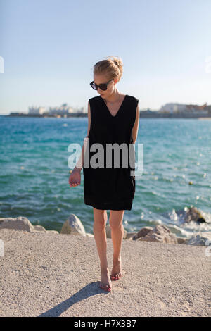 Blonde woman standing by the sea in summer Stock Photo - Alamy
