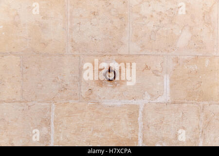 Stone wall. Beige stoned wall of bricks with metal tab on it. Stock Photo