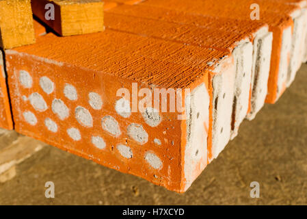 Red bricks with holes filled with cement. Stock Photo