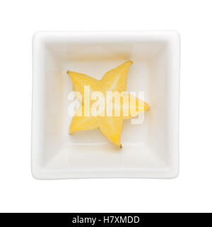 Slice of starfruit in a square bowl isolated on white background Stock Photo