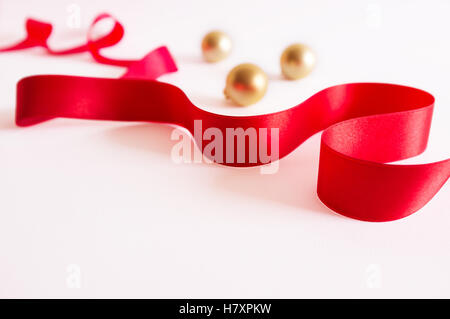 Golden christmas balls with red ribbon on white background. Stock Photo