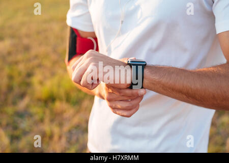Close up of sports male hands with smartwatch outdoors Stock Photo