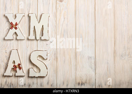 Wooden white XMAS letters on a white wooden background. Stock Photo