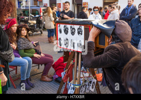 Madrid, Spain - November 6, 2016: street photographer taking pictures with a vintage handmade camera at El Rastro flea market Stock Photo