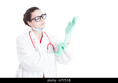 Female doctor or surgeon putting gloves on preparing for operation isolated on white background Stock Photo
