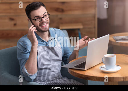 Surprised happy young man talking on cellphone. Stock Photo