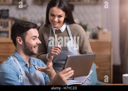 Delighted young couple making notes and using tablet. Stock Photo
